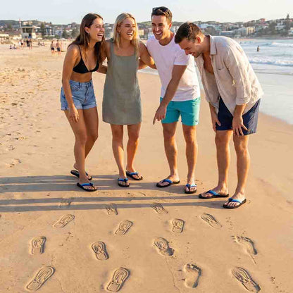 Group of friends laughing on the beach with Soleprint trails behind them